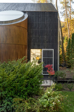 Suburban home from natural materials with landscaping around