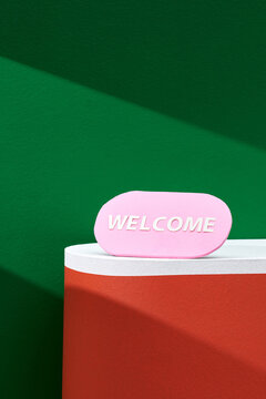 Pink board with welcome sign on color background