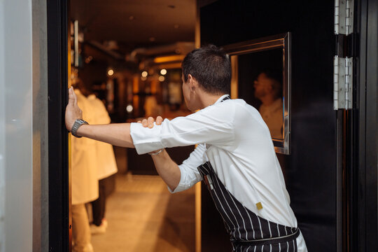Male cook standing near doorway in restaurant