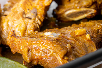 Pork ribs cooked in a pressure cooker on a wooden table.