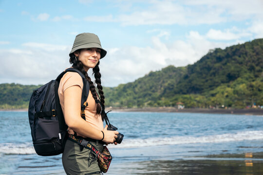 Portrait of a traveler and photographer woman on a beach with jungle