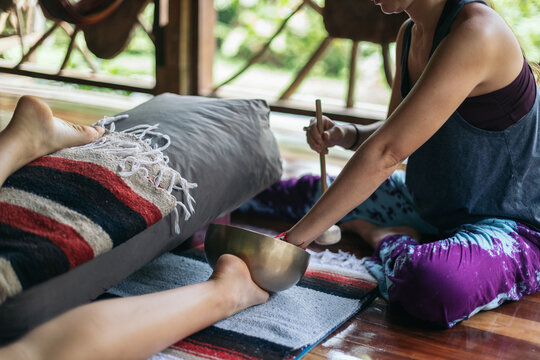 Yoga teacher practicing restorative yoga with singing bowls