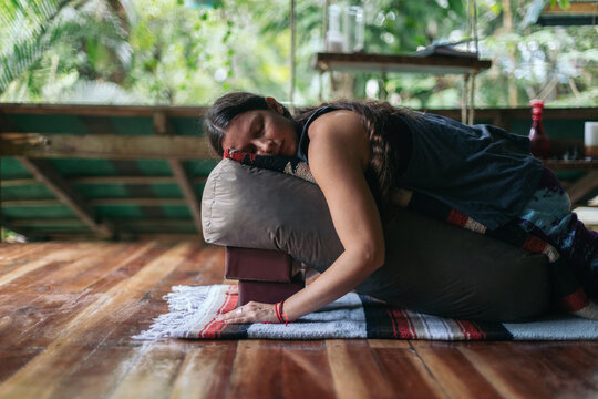 Woman practicing restorative yoga on an outdoor terrace