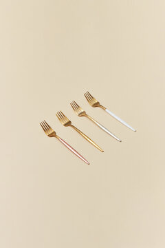 Four forks in gold, silver and pink colors.