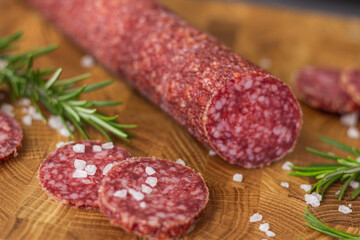 Sausage on a wooden board. Sausage with raspberry and salt. Sausage on top. Macro Sausage