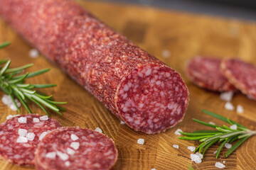 Sausage on a wooden board. Sausage with raspberry and salt. Sausage on top. Macro Sausage