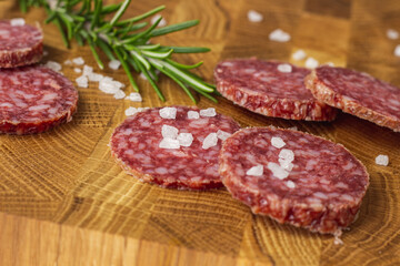 Sausage on a wooden board. Sausage with raspberry and salt. Sausage on top. Macro Sausage