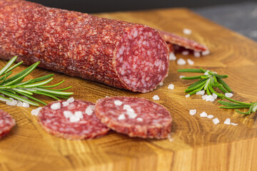 Sausage on a wooden board. Sausage with raspberry and salt. Sausage on top. Macro Sausage