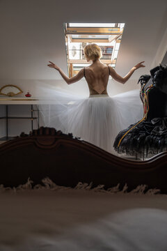 Female ballet dancer posing inside attic hotel room
