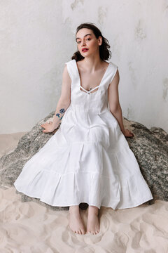 Elegant woman in white wedding dress in studio