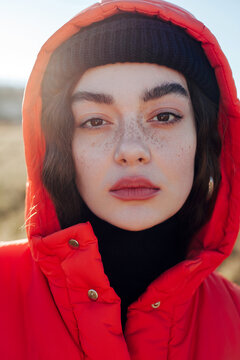 Pretty woman with makeup and freckles in nature. Cold sunny field. 
