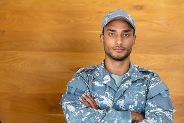 Portrait of biracial male soldier wearing military uniform and cap, looking at camera, copy space