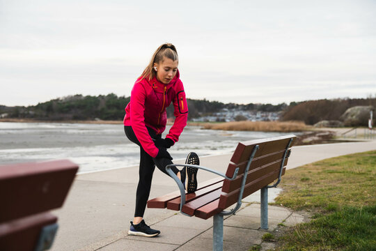 Young woman out on a run stretching