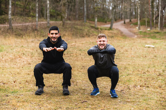 Workout partners doing squads outdoors