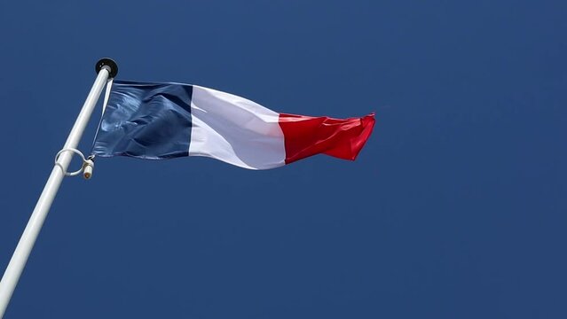 The flag of France flutters in the wind against a blue sky in a sunny day, Bastille Day and French National Day 14 July concept