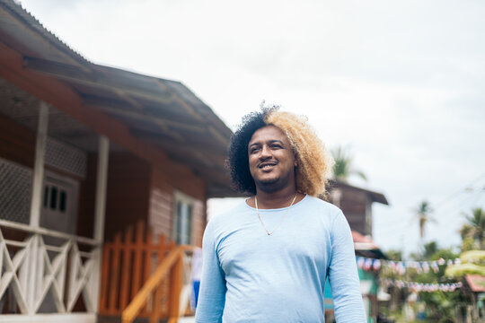 Man with colored afro hair walking on an island in Panama