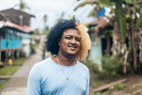 Man with colored afro hair walking on an island