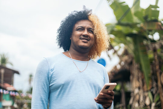 Man with colored afro hair using smartphone
