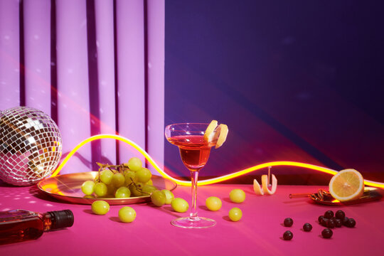 Wine glasses and christmas decor on colored holiday background.