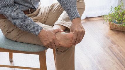 痛風・足のマッサージをする男性　イメージ