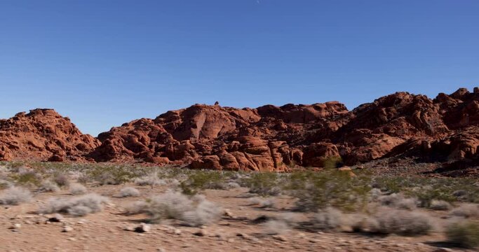 Drive Plate-Rugged red rock formations against a clear blue sky pass by in Valley of Fire State Park in the desert of Nevada, USA