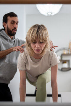 Trainer helping woman with control front exercise