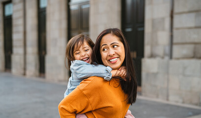 Happy southeast Asian mother with her daughter having fun in the city center - Lovely family outdoor