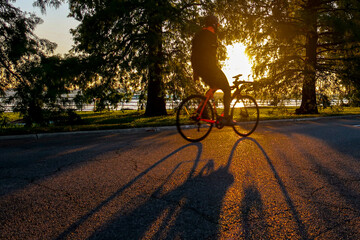 Cyclist riding through a sunset