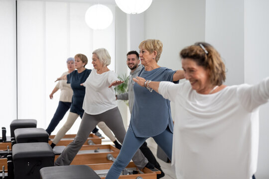 Active senior ladies exercising on Pilates reformers