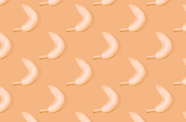 Pattern of white bananas on orange pastel background