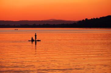 Naklejka na ściany i meble Tourists enjoying the sunset at Sempach lake in Switzerland, Europe 