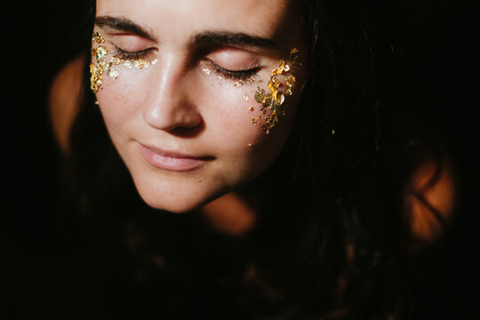 Woman with golden party makeup portrait eyes closed