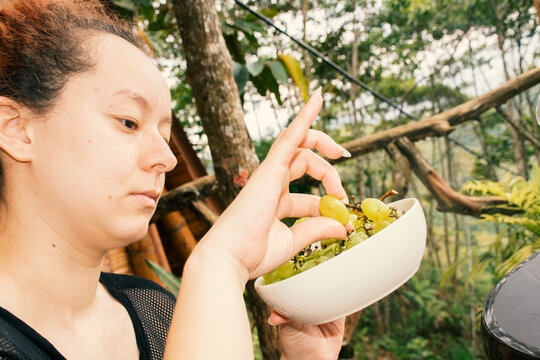 Woman eating green grapes