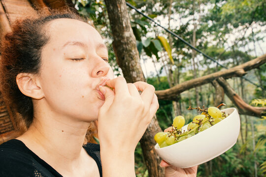 Woman eating green grapes