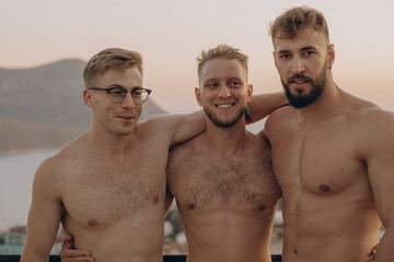 Athletic friends hugging on shoulder on terrace