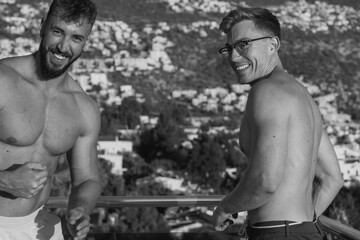 Cheerful muscular men standing on terrace