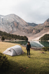 Girl doing camping near a lake in pyrenees.