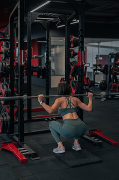 Fit sportive female exercising with power cage