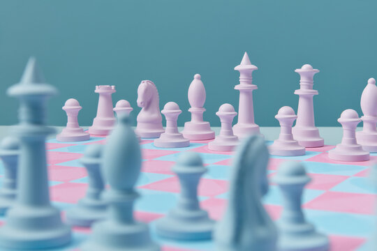 Blue and pink figures arranged on chess board.