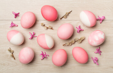 Naklejka na ściany i meble Pink Easter eggs with decor on wooden background, top view