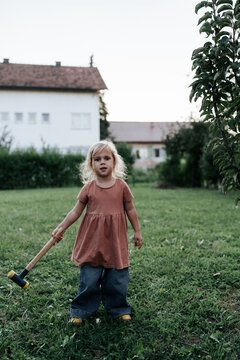 Girl harvests apples with a hammer