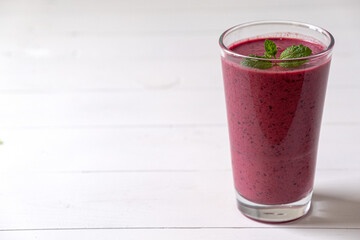 Tasty blueberry smoothie in glass on white background
