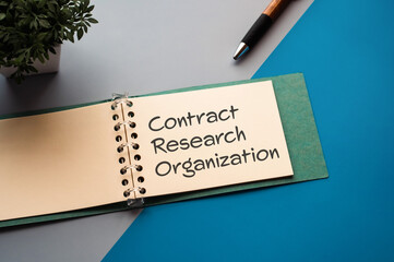 There is a notebook with the word Contract Research Organization. It is eye-catching image.