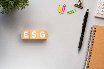 There is wood cube with the word ESG.It is an abbreviation for Environment, Social, Governance as eye-catching image.