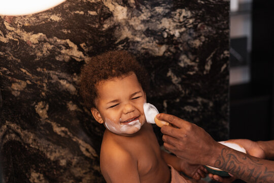 Anonymous Father Appying Shaving Foam To A Kid's Face 