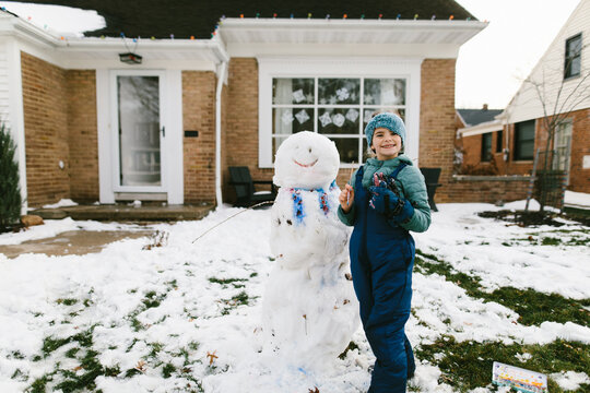 Girl uses paint to decorate snowman