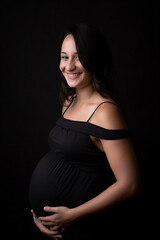 Mulher grávida sorrindo segurando a foto da barriga no estúdio