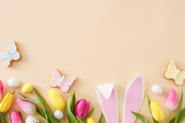 Easter celebration idea. Flat lay photo of easter bunny ears white yellow eggs tulips flowers and...