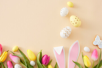 Easter celebration concept. Flat lay composition of easter bunny ears colorful eggs yellow pink...