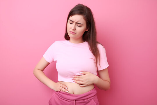 Mulher jovem com apendicite no fundo rosa